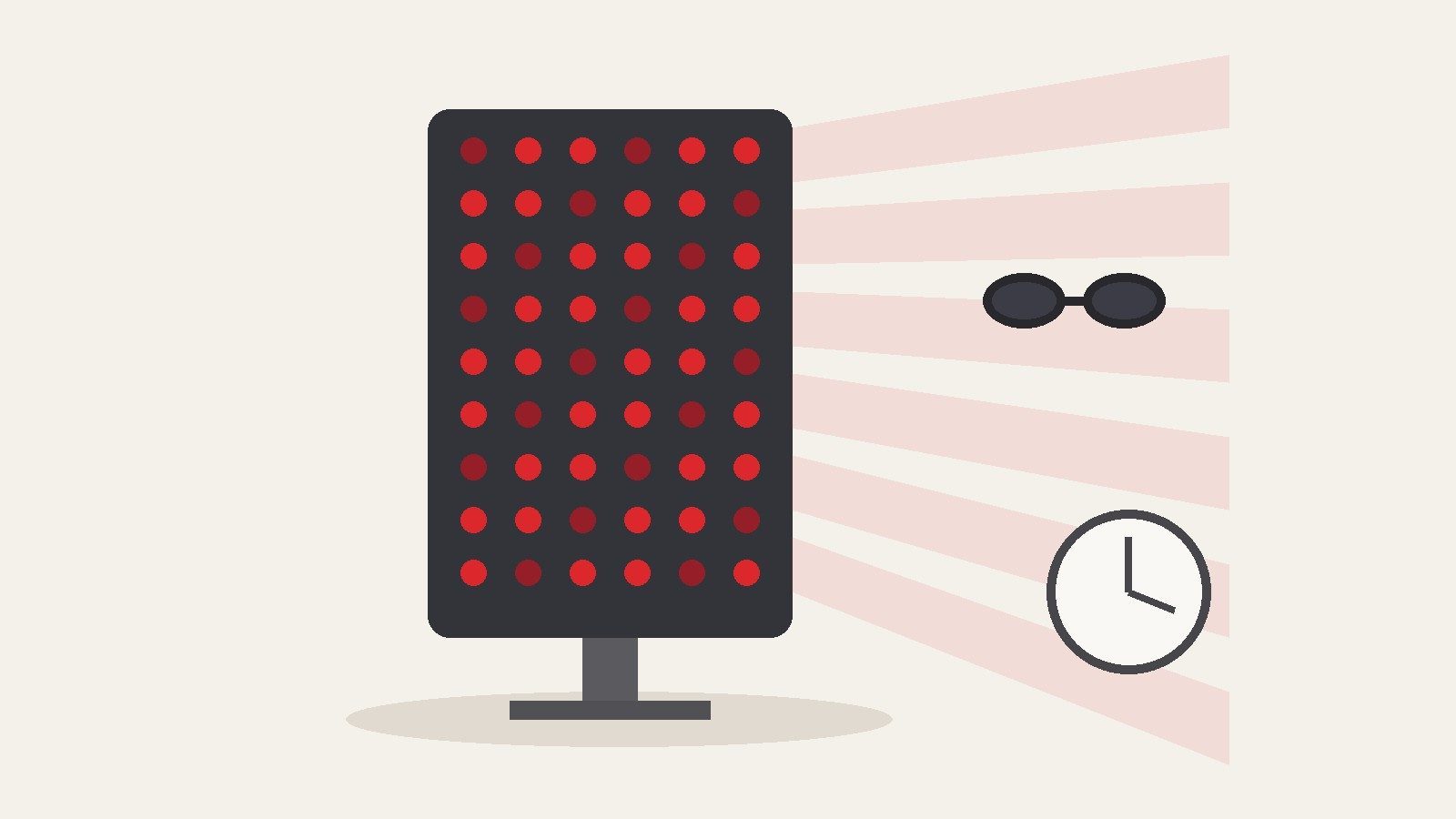 A red LED light panel on a stand beside protective goggles and a clock without numerals